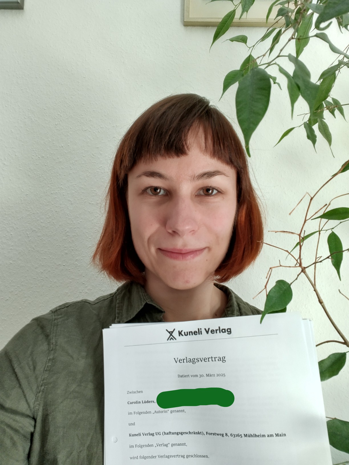 Das Bild zeigt mich, mit dem Vertrag vom Kuneli Verlag in der Hand.