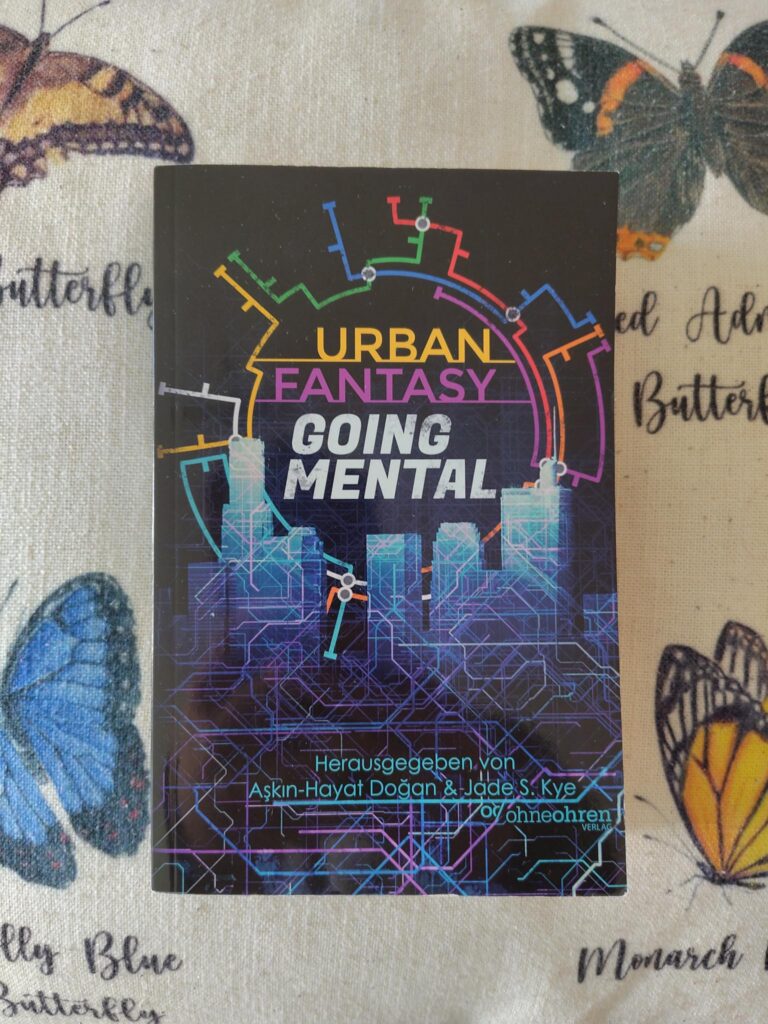 Das Buch "Urban Fantasy Going Mental" liegt auf einem Kissen.