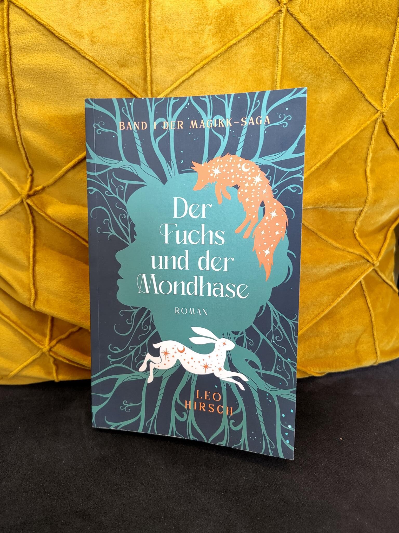Das Buch "Der Fuchs und der Mondhase", vor einem goldenen Kissen.